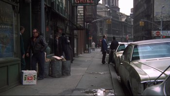 Movie still from “Mean Streets” (1973), directed by Martin Scorsese – A group of people standing on the side of the street; Wide shot, Over the shoulder angle