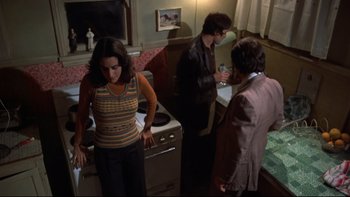 Movie still from “Mean Streets” (1973), directed by Martin Scorsese – A group of people standing in a kitchen next to an oven; Medium shot, High angle