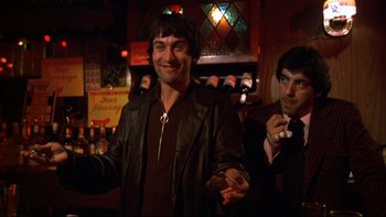 Movie still from “Mean Streets” (1973), directed by Martin Scorsese – A man in a leather jacket is holding a cigarette; Medium shot, Low angle