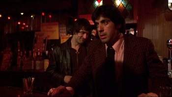 Movie still from “Mean Streets” (1973), directed by Martin Scorsese – Two men are standing in front of a bar; Medium shot, Low angle