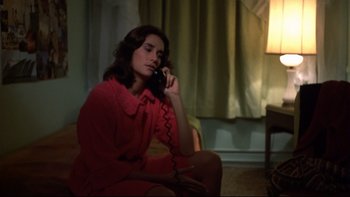 Movie still from “Mean Streets” (1973), directed by Martin Scorsese – A woman sitting on the ground talking on a phone; Medium shot, High angle