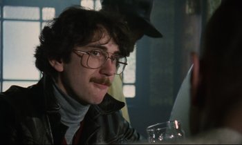 Movie still from “Meantime” (1983), directed by Mike Leigh – A man sitting at a table with a glass of wine; Close Up shot, Low angle