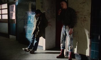 Movie still from “Meantime” (1983), directed by Mike Leigh – Two men standing next to each other in a building; Wide shot, Low angle