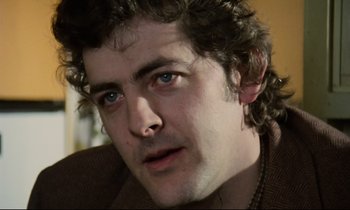 Movie still from “Meantime” (1983), directed by Mike Leigh – A person wearing a brown jacket; Close Up shot, Low angle