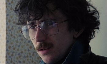 Movie still from “Meantime” (1983), directed by Mike Leigh – A person wearing glasses; Close Up shot, Low angle