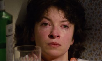 Movie still from “Meantime” (1983), directed by Mike Leigh – A person with a glass of water; Close Up shot, High angle