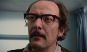 Movie still from “Meantime” (1983), directed by Mike Leigh – A person wearing glasses; Close Up shot, Low angle