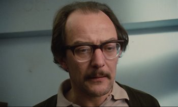 Movie still from “Meantime” (1983), directed by Mike Leigh – A person wearing glasses; Close Up shot, Low angle