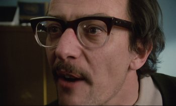 Movie still from “Meantime” (1983), directed by Mike Leigh – A person wearing glasses; Close Up shot, Low angle