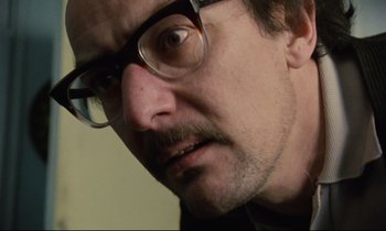 Movie still from “Meantime” (1983), directed by Mike Leigh – A person wearing glasses; Close Up shot, Low angle