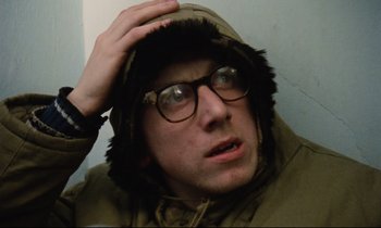 Movie still from “Meantime” (1983), directed by Mike Leigh – A young man wearing glasses and a hooded jacket; Close Up shot, Low angle