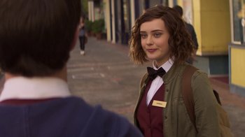 Movie still from “13 Reasons Why” (2017), created by Brian Yorkey – A young woman wearing a vest and a bow tie standing next to a man; Close Up shot, Over the shoulder angle