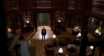 Movie still from “Meet Joe Black” (1998), directed by Martin Brest – A man in a suit standing in a room with many books; Extreme Wide shot, High angle