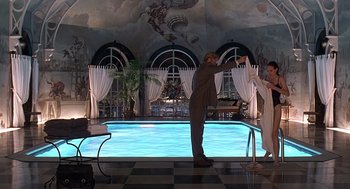 Movie still from “Meet Joe Black” (1998), directed by Martin Brest – A man and a woman standing in front of an indoor swimming pool; Wide shot, Over the shoulder angle