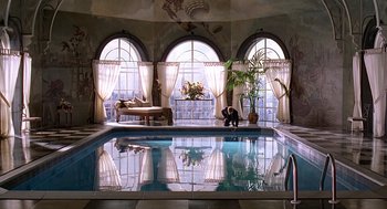 Movie still from “Meet Joe Black” (1998), directed by Martin Brest – A person sitting in a pool in a room with large windows; Extreme Wide shot, Low angle