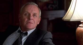 Movie still from “Meet Joe Black” (1998), directed by Martin Brest – An older man wearing a suit and tie looking at the camera; Close Up shot, Low angle