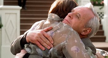 Movie still from “Meet Joe Black” (1998), directed by Martin Brest – An older man and a younger woman hugging each other; Close Up shot, Over the shoulder angle