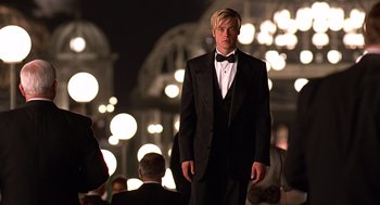 Movie still from “Meet Joe Black” (1998), directed by Martin Brest – A man in a tuxedo standing in front of a group of people; Medium shot, Low angle