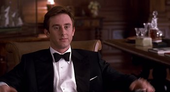 Movie still from “Meet Joe Black” (1998), directed by Martin Brest – A man in a tuxedo sitting in a chair in a room; Medium shot, Low angle