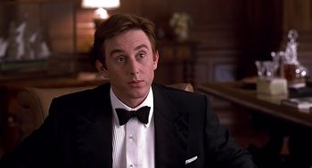 Movie still from “Meet Joe Black” (1998), directed by Martin Brest – A man in a tuxedo sitting in front of a wooden table; Close Up shot, Over the shoulder angle