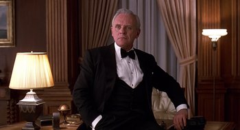 Movie still from “Meet Joe Black” (1998), directed by Martin Brest – An older man wearing a tuxedo sitting in a chair; Medium shot, Low angle