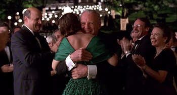 Movie still from “Meet Joe Black” (1998), directed by Martin Brest – A man and a woman hugging at a formal event; Medium shot, Over the shoulder angle