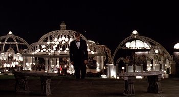 Movie still from “Meet Joe Black” (1998), directed by Martin Brest – A man in a tuxedo standing in front of an outdoor stage; Wide shot, Low angle