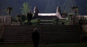 Movie still from “Meet Joe Black” (1998), directed by Martin Brest – Two men in suits standing in front of a stone bridge; Extreme Wide shot, Low angle