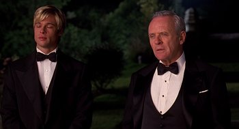 Movie still from “Meet Joe Black” (1998), directed by Martin Brest – A man in a tuxedo standing next to another man in a suit; Medium shot, Low angle