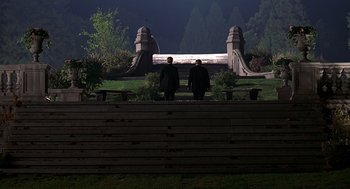Movie still from “Meet Joe Black” (1998), directed by Martin Brest – Two men are standing in front of a wooden bench; Extreme Wide shot, High angle