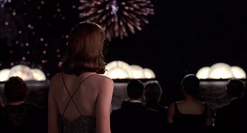 Movie still from “Meet Joe Black” (1998), directed by Martin Brest – A woman standing in front of fireworks at night; Medium shot, Over the shoulder angle