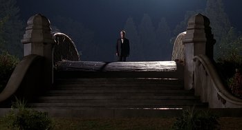 Movie still from “Meet Joe Black” (1998), directed by Martin Brest – A man in a suit standing on top of a wooden structure; Extreme Wide shot, Low angle