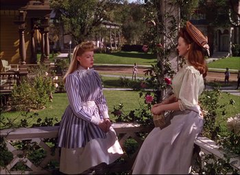 Movie still from “Meet Me in St. Louis” (1944), directed by Vincente Minnelli – Two women are sitting on a bench in a garden; Medium shot, High angle