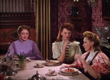 Movie still from “Meet Me in St. Louis” (1944), directed by Vincente Minnelli – A group of women sitting at a table with plates of food; Medium shot, High angle