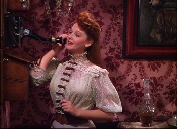 Movie still from “Meet Me in St. Louis” (1944), directed by Vincente Minnelli – A woman in a white dress talking on a phone; Medium shot, High angle