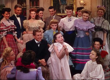 Movie still from “Meet Me in St. Louis” (1944), directed by Vincente Minnelli – A group of people standing around each other in a room; Wide shot, High angle