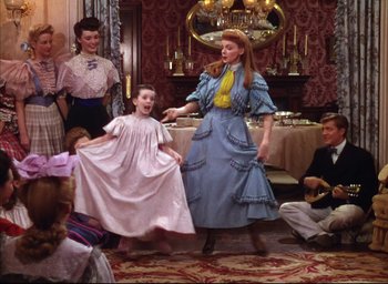 Movie still from “Meet Me in St. Louis” (1944), directed by Vincente Minnelli – Two women and a little girl dancing in a living room; Wide shot, High angle