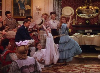 Movie still from “Meet Me in St. Louis” (1944), directed by Vincente Minnelli – A group of people in a living room; Wide shot, High angle
