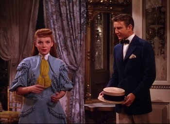 Movie still from “Meet Me in St. Louis” (1944), directed by Vincente Minnelli – A man and a woman standing next to each other in a room; Medium shot, High angle