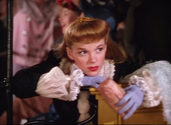 Movie still from “Meet Me in St. Louis” (1944), directed by Vincente Minnelli – A woman in a black and white dress and blue gloves; Close Up shot, Low angle