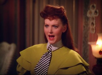 Movie still from “Meet Me in St. Louis” (1944), directed by Vincente Minnelli – A red headed woman wearing a yellow coat and a striped tie; Close Up shot, High angle