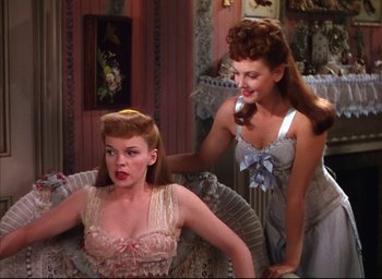 Movie still from “Meet Me in St. Louis” (1944), directed by Vincente Minnelli – Two women in a room one is combing the other's hair; Medium shot, High angle