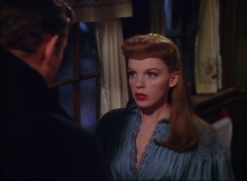 Movie still from “Meet Me in St. Louis” (1944), directed by Vincente Minnelli – A woman in a blue dress looking at a man in a black suit; Close Up shot, Over the shoulder angle