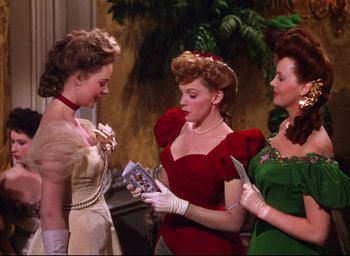 Movie still from “Meet Me in St. Louis” (1944), directed by Vincente Minnelli – A group of women standing next to each other; Medium shot, Over the shoulder angle