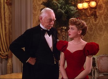 Movie still from “Meet Me in St. Louis” (1944), directed by Vincente Minnelli – An older man and a young woman standing next to each other; Medium shot, Low angle