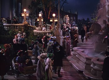 Movie still from “Meet Me in St. Louis” (1944), directed by Vincente Minnelli – A crowd of people walking down a street at night; Extreme Wide shot, High angle