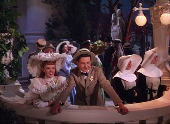 Movie still from “Meet Me in St. Louis” (1944), directed by Vincente Minnelli – A man and woman in a dress suit and hat; Medium shot, High angle
