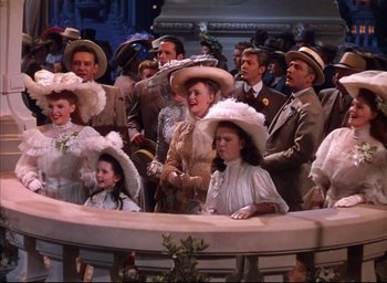 Movie still from “Meet Me in St. Louis” (1944), directed by Vincente Minnelli – A group of people wearing fancy hats in a crowd; Wide shot, High angle
