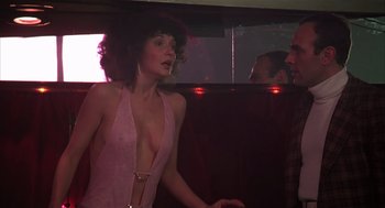 Movie still from “Melvin and Howard” (1980), directed by Jonathan Demme – A woman in a pink dress standing next to a man in a black suit; Medium shot, Over the shoulder angle