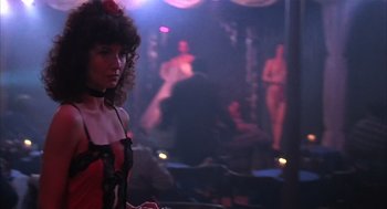 Movie still from “Melvin and Howard” (1980), directed by Jonathan Demme – A woman standing in front of a mirror in a room; Medium shot, Over the shoulder angle